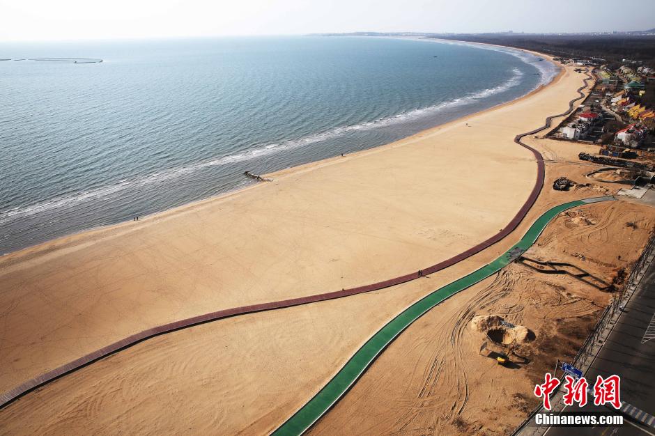 3月13日，秦皇島萬(wàn)米臨海沙灘木棧道。據(jù)了解，該木棧道全長(zhǎng)約4200米，與北戴河區(qū)原有的7500米木棧道對(duì)接后全線總長(zhǎng)度1.17萬(wàn)米，整個(gè)木棧道東起秦皇島體育基地游船碼頭，西至北戴河濕地公園，呈波浪形蜿蜒10.4公里海岸線。 中新社發(fā) 曹建雄 攝 CNSPHOTO
