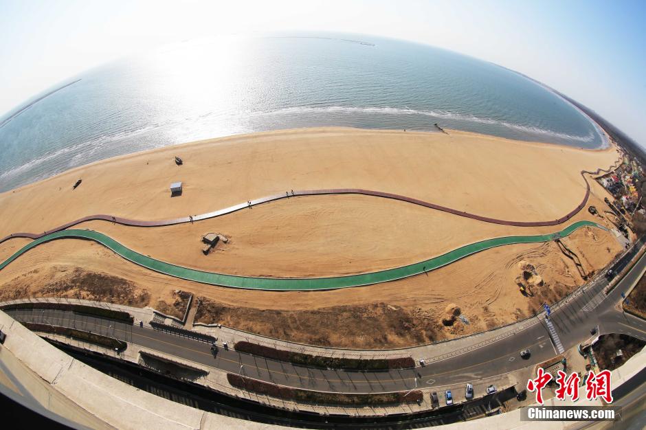 3月13日，秦皇島萬(wàn)米臨海沙灘木棧道。據(jù)了解，該木棧道全長(zhǎng)約4200米，與北戴河區(qū)原有的7500米木棧道對(duì)接后全線總長(zhǎng)度1.17萬(wàn)米，整個(gè)木棧道東起秦皇島體育基地游船碼頭，西至北戴河濕地公園，呈波浪形蜿蜒10.4公里海岸線。 中新社發(fā) 曹建雄 攝 CNSPHOTO